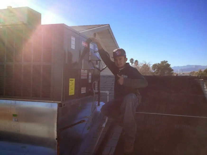 HVAC technician performing AC Tune-Up on a rooftop unit in South Laurel